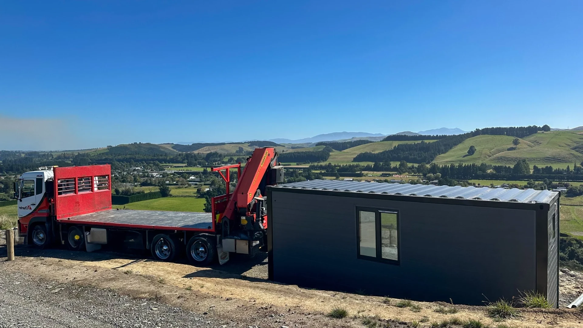 An Expanders tiny home being delivered by crane truck to a rural New Zealand site