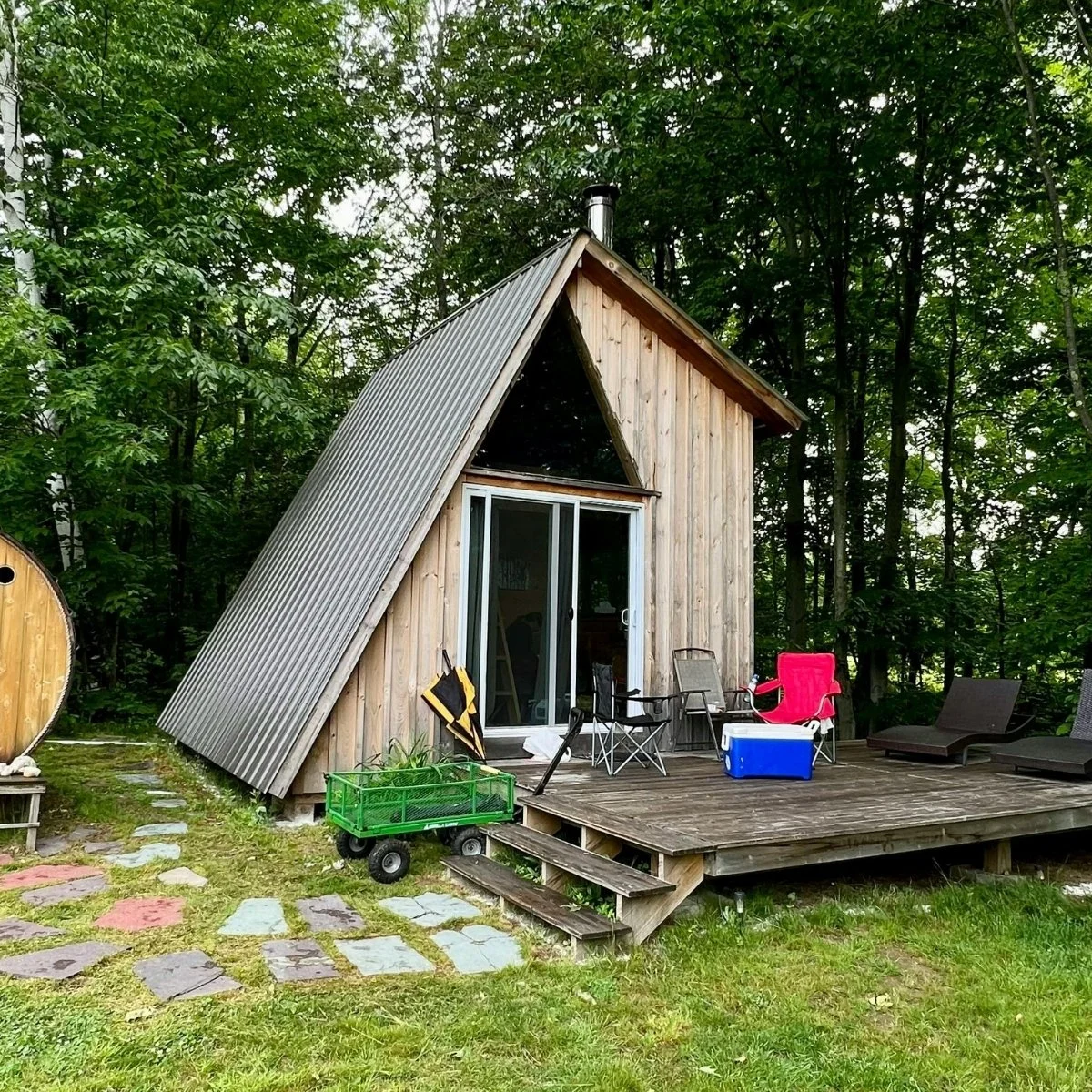 A compact A-frame cabin set in a forest clearing